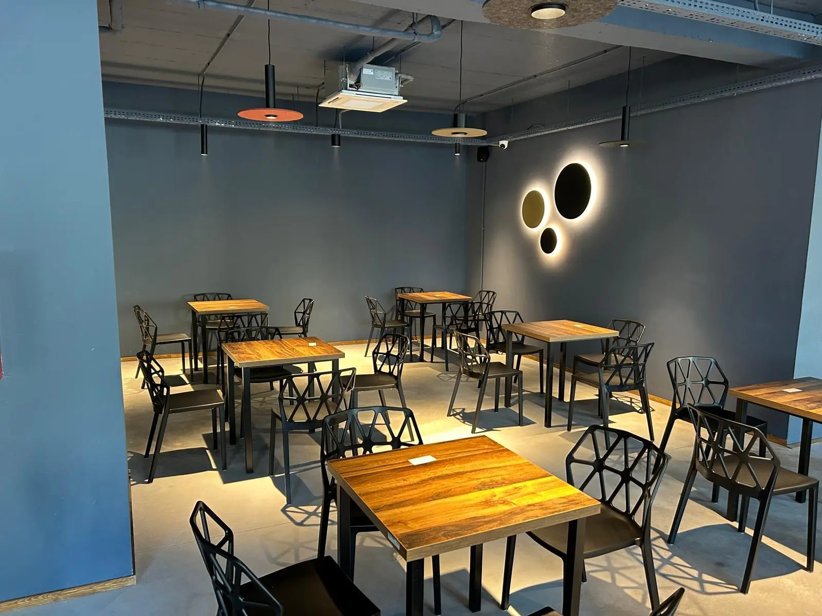 Interior restaurant cu elemente industriale și iluminat cald